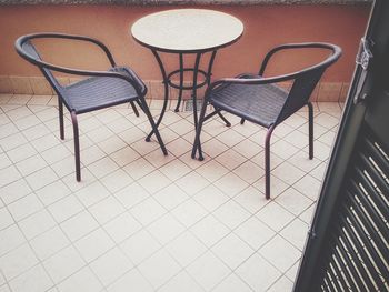 High angle view of empty chairs and table at sidewalk cafe