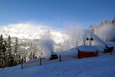 Snow covered landscape against blue sky