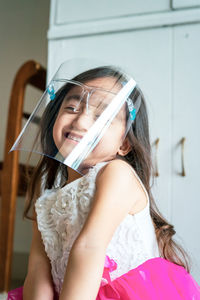 A toddler girl wearing the face protection shield. a safety corona mask during covid-19 pandemic.