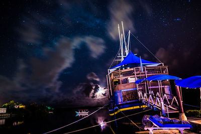 Low angle view of illuminated ship against sky at night