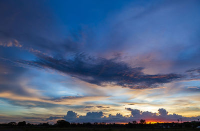 Silhouette landscape against dramatic sky during sunset