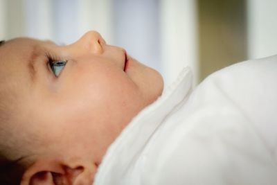 Portrait of cute baby lying on bed