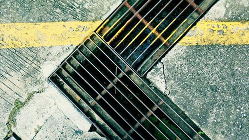 High angle view of metal grate on road