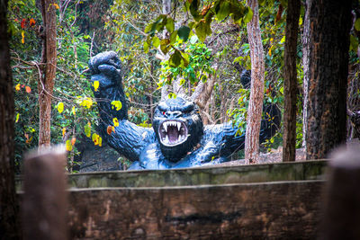 Statue against tree trunk