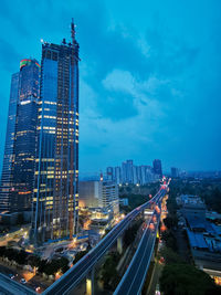 Aerial view of illuminated buildings in city against sky