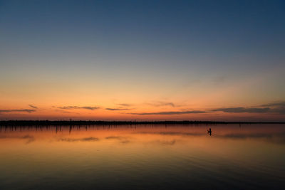 Scenic view of lake against clear sky during sunset