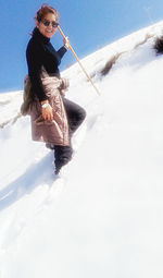 Woman walking on snow covered mountain