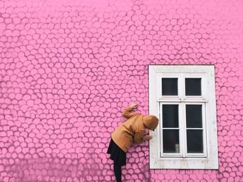 Woman standing by wall