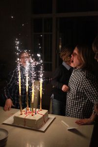 Sparklers burning on birthday cake by children at home