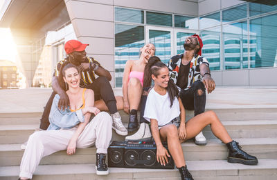 Women sitting on wall of building