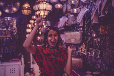 Close-up of young woman holding jewelry at market 