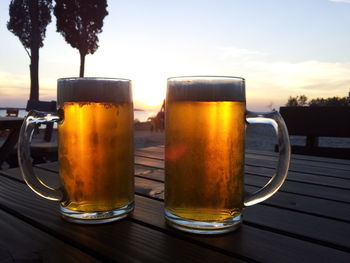 Beer glass on table against sky