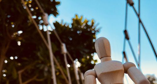 Low angle view of a wooden dummy against the sky