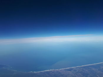 Aerial view of sea against blue sky