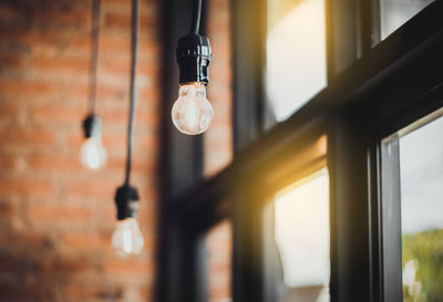 Low angle view of light bulbs hanging from ceiling