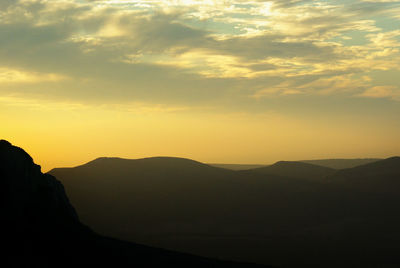 Scenic view of silhouette mountains against sky during sunset