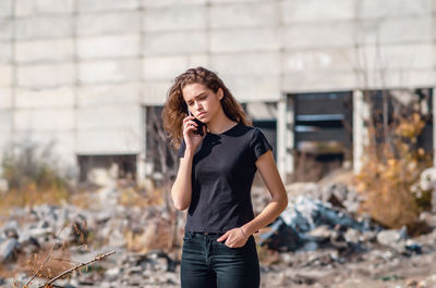 Stylish young woman talking on the phone in industrial district