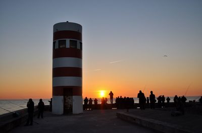 Silhouette of people at beach during sunset