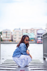 Portrait of woman sitting against sky