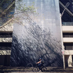 Man riding bicycle on road in city