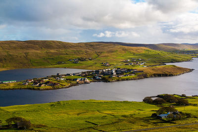 Water, hills, and small town in norther scotland in shetland united kingdom