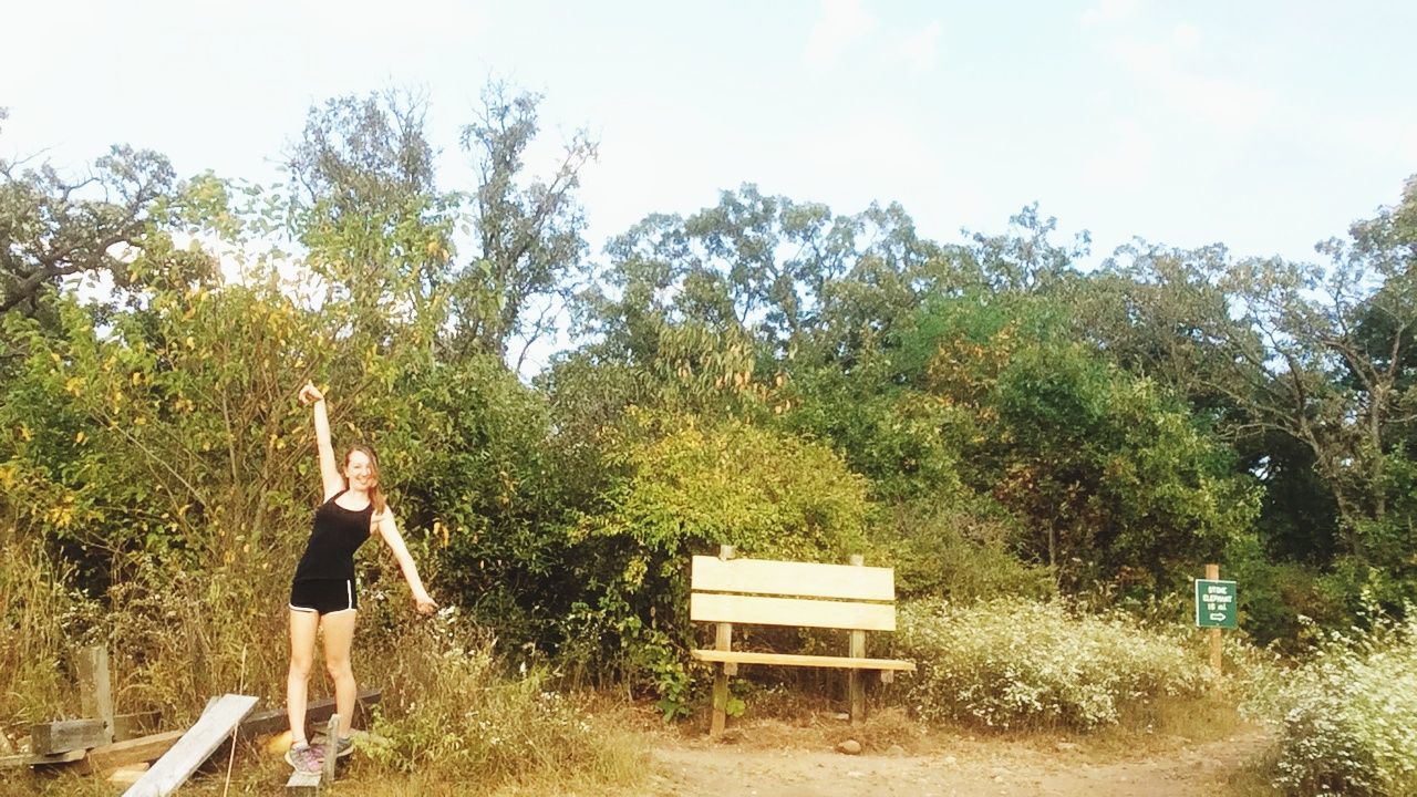 MAN STANDING AGAINST TREES