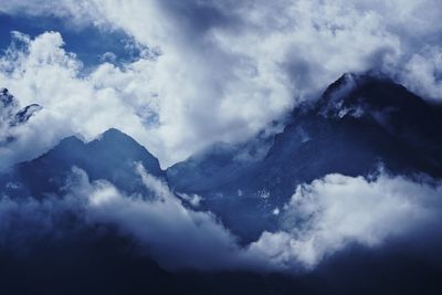 Low angle view of clouds over mountains
