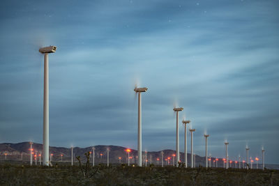 Street lights on field against sky at dusk