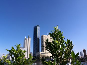 Low angle view of modern buildings against clear blue sky