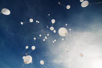 White balloons fly up into the blue sky. the release of festive balloons in the clouds. celebration 