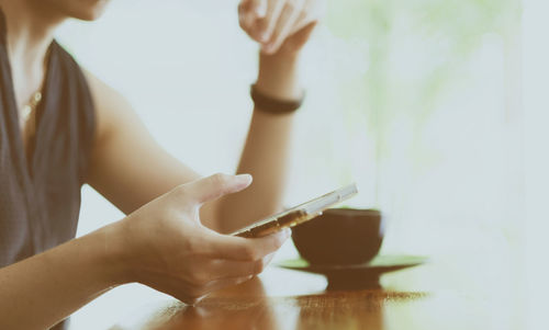 Midsection of woman using mobile phone