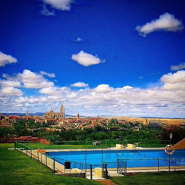 sky, blue, built structure, cloud - sky, architecture, building exterior, cloud, fence, grass, railing, sea, water, landscape, scenics, tranquil scene, nature, tranquility, field, beauty in nature, day