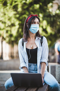 Full length of young woman using mobile phone