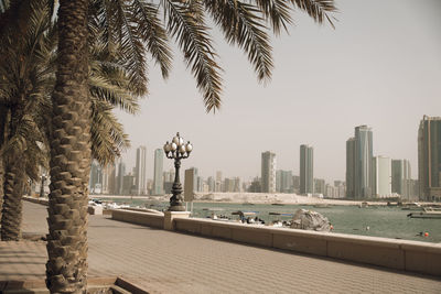 Buildings by sea against clear sky