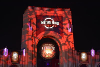 Low angle view of illuminated sign on building at night