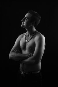 Young man looking away against black background