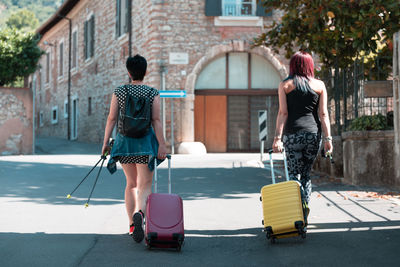 Rear view of women walking on street in city