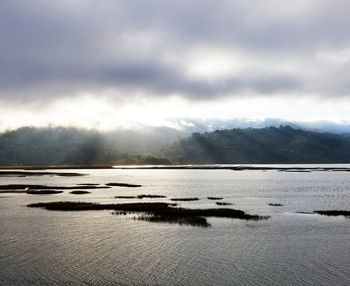 Scenic view of lake by mountains against sky