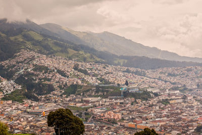 Aerial view of cityscape and mountains against sky