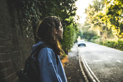 Rear view of woman standing against trees