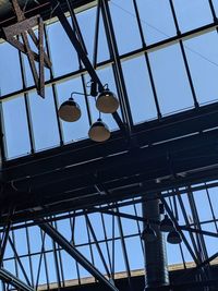 Low angle view of electric lamp on building against sky