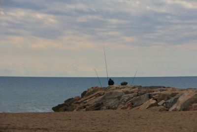 Scenic view of rocks on beach against sky