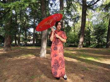 Portrait of a smiling woman standing against trees
