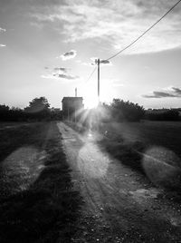 Empty road against sky on sunny day