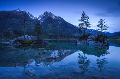 Scenic view of lake by trees against sky