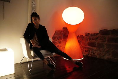 Young woman sitting on chair at home