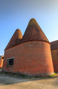 Low angle view of old building against clear blue sky