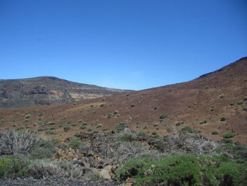 Scenic view of mountains against clear blue sky