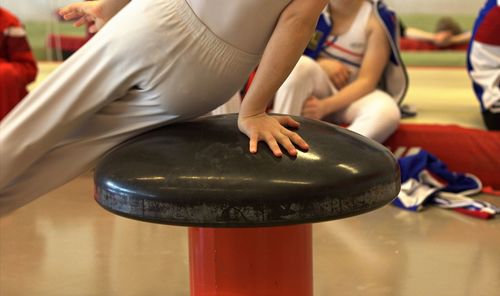 Midsection of child balancing on equipment in gymnastics class