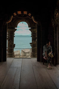 Man sitting on chair in the interior of a buddhist temple